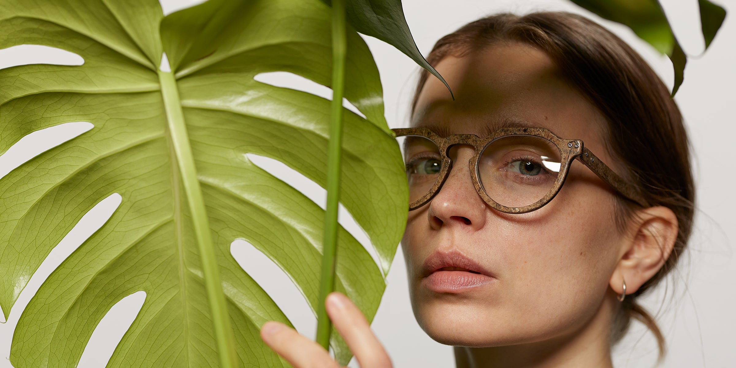 Hemp made eyewear frame worn by a woman next to a plant